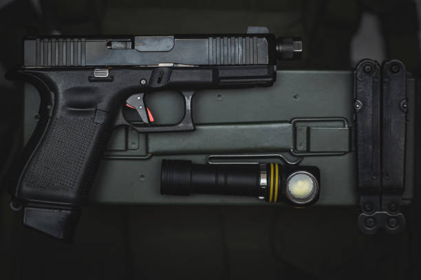 istock Tactical equipment and weapons, pistol with threaded barrel for suppressor, flashlight and multitool. 1851897430