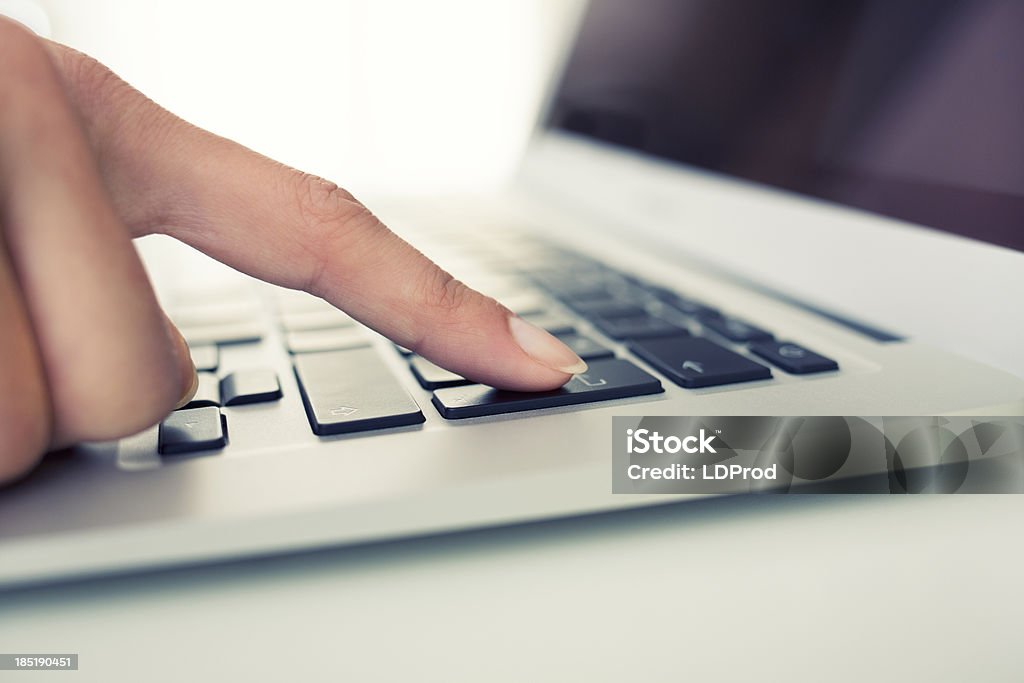 Female hand using computer keyboard, enter button woman laptop finger indoor desk Adult Stock Photo