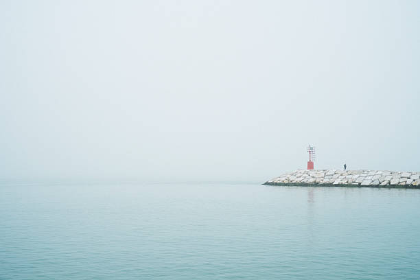 istock pier and lighthouse with fog 185190916