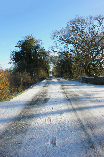 A picturesque winter scene is depicted, with a winding road blanketed in snowl