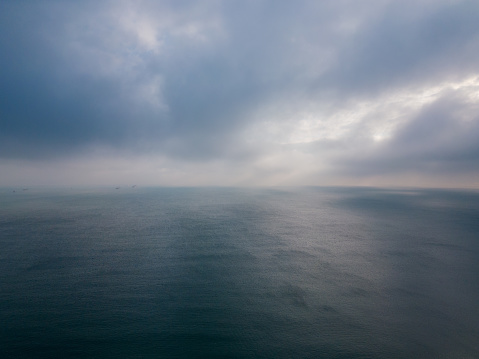 Aerial view of a dark sea, horizon, and dramatic sky before a storm.