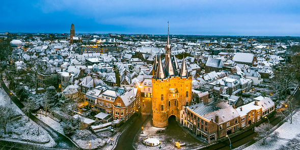 Zwolle Sassenpoort old gate during a cold winter morning with snow on the rooftops in the downtown district seen from above. The Sassenpoort was constructed in the 14th century, specifically between 1406 and 1409, and served as one of the main entrances to the fortified city of Zwolle. It was built as part of the city's defensive walls and was primarily used to control access into the city, as well as to protect its inhabitants from potential threats.

The gate's name, 