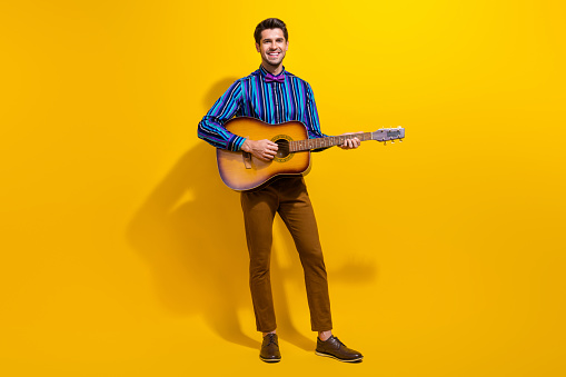 Young male musician posing with his acoustic guitar. About 25 years old, Caucasian man.