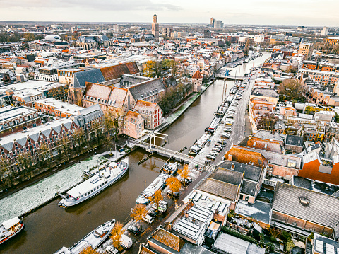 View on the Thorbeckegracht in Zwolle, Overijssel The Netherlands, during a beautiful cold winter morning with some snow on the rooftops and classic sailing freight ships in the canal. High angle drone view.