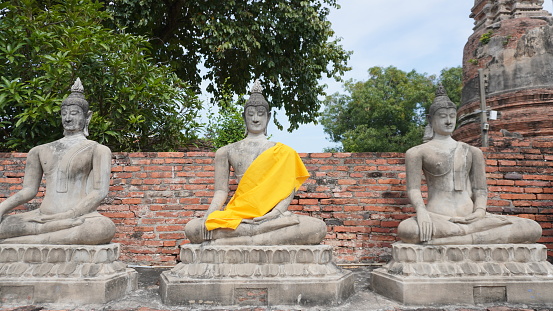 Buddha stone statue wearing monk robe at temple