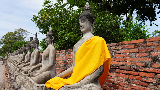 Buddha sculpture wearing yellow monk robes in the temple