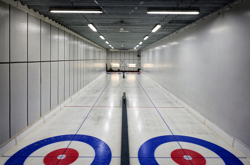 An indoor curling rink illuminated by bright lights