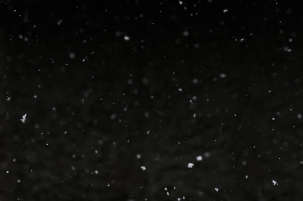 istock Bokeh of white snow on a black background. Snowfall - design element. 1851995325