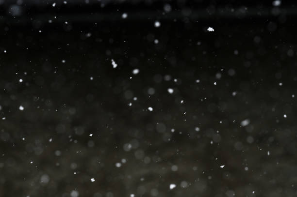 istock Bokeh of white snow on a black background. Snowfall - design element. 1851995852