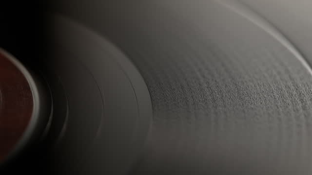 Tracking Shot of a Spinning Vinyl. The Camera Moves from the Label of the Record to the Right, over the Wooden Surface of the Turntable