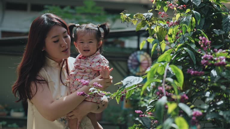 Chinese New Year Chinese mother and daughter bonding time at yard garden in morning