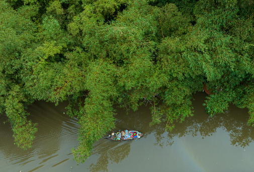 Small boat running on a canal in the countryside in the Mekong Delta, Hau Giang province, Vietnam