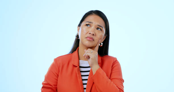 istock Asian woman, thinking and question for idea, plan and concept with problem, unsure and isolated on studio background. Decision, confused and mockup space with choice, wondering and concentration 1852028125