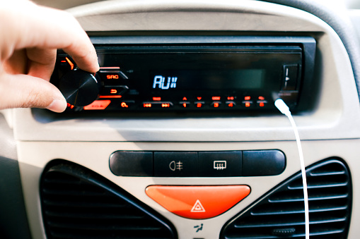 Close-up photo of a hand turning on the in-car radio