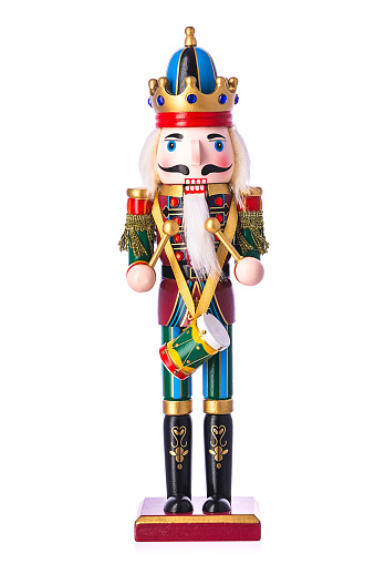 Traditional Christmas nutcracker wooden figure. Beautiful, festive toy soldier decoration, with copy space and tree lights bokeh in background.