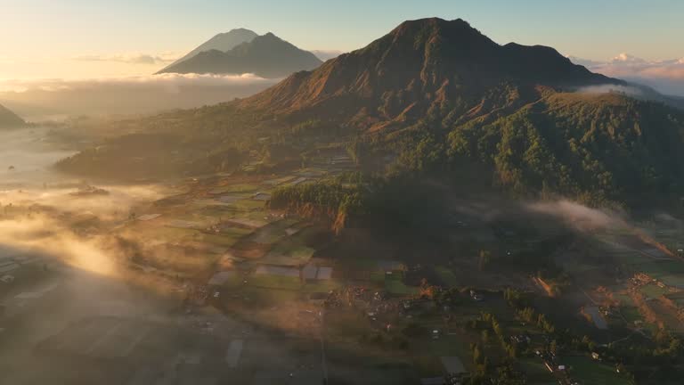 Aerial Drone of Pinggan Sunrise View Pohon Cinta, mt. Batur and mt. Agung With Moving Fog and Cloud, Kintamani, Kabupaten Bangli, Bali, Indonesia