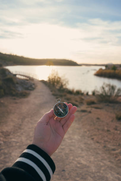 istock A hand holds a compass with a landscape with a lagoon in the background 1852062254
