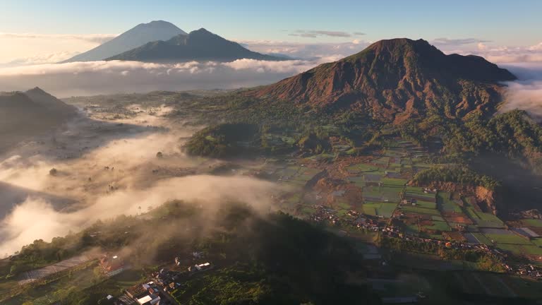 Aerial Drone of Pinggan Sunrise View Pohon Cinta, mt. Batur and mt. Agung With Moving Fog and Cloud, Kintamani, Kabupaten Bangli, Bali, Indonesia