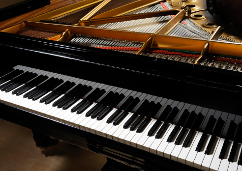 Classical black grand piano with keyboard in foreground. More piano pictures...