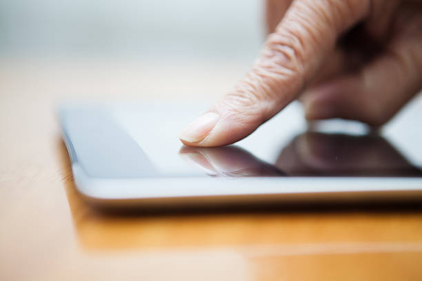 istock Elderly person's finger on a digital tablet 185207099