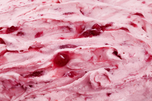 Closeup and cropped view of ice cream with strawberry swirls mixed in. Horizontal shot.See similars: