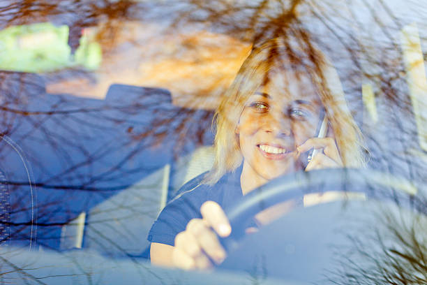 istock Young woman in the car using mobile phone 185207851