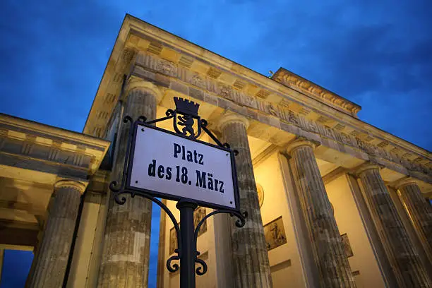 "The Platz des 18. MArz (18th of March Square) is the small, semicircular plaza on the west side of the Brandenburg Gate. The name Platz des 18. MArz is in remembrance of the revolution of 1848 and the first free and democratic parliamentary elections in the former GDR on March 18, 1990.Canon 5D Mark II and wide angle lens with focus on the sign."