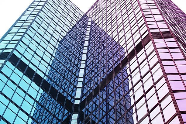 Modern Glass Architecture Interesting reflection and lines formed by two modern glass architecture. mergers and acquisitions photos stock pictures, royalty-free photos & images
