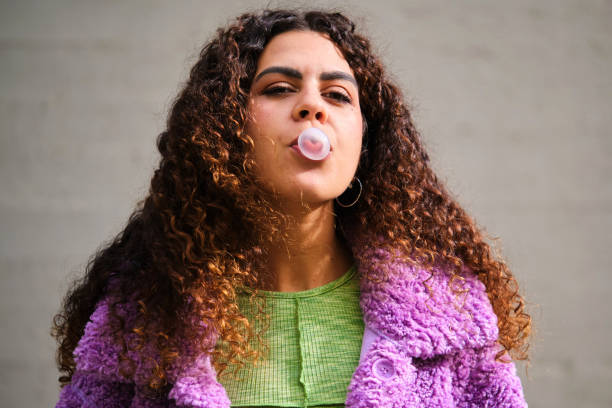 istock Young Spanish woman blowing bubble with a chewing gum. 1852094053