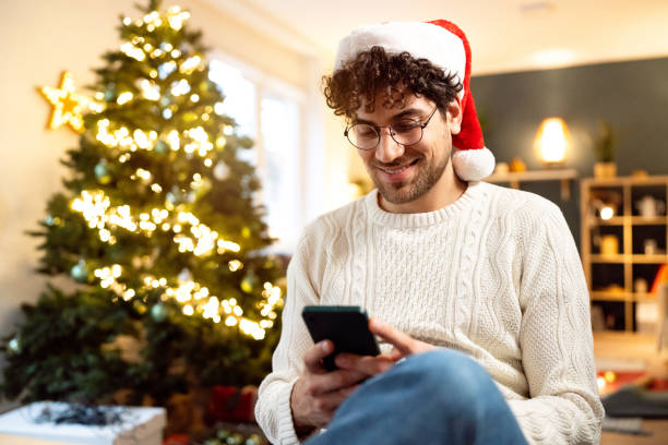 istock Young man using his phone while spending Christmas holiday at home 1852097842