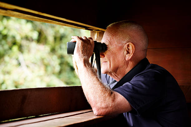 istock Senior man observing wildlife through binoculars 185210482
