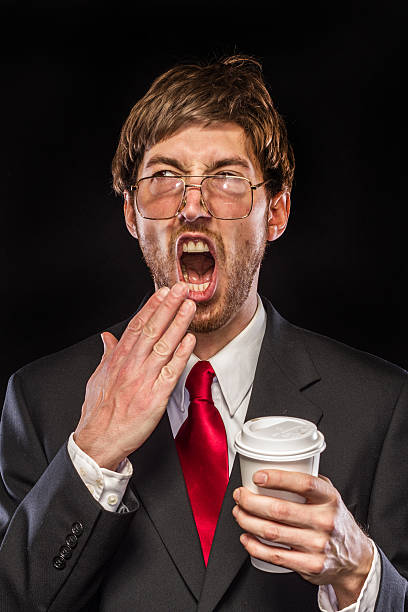 istock Comical Nerdy Businessman on Black Background, Yawning 185210525