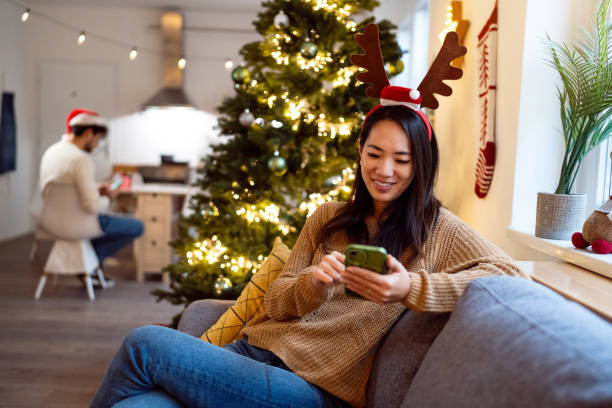 istock Woman using her phone while spending Christmas holiday at home 1852105818