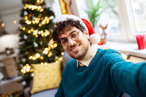 Selfie of a handsome young man spending Christmas holiday at home.