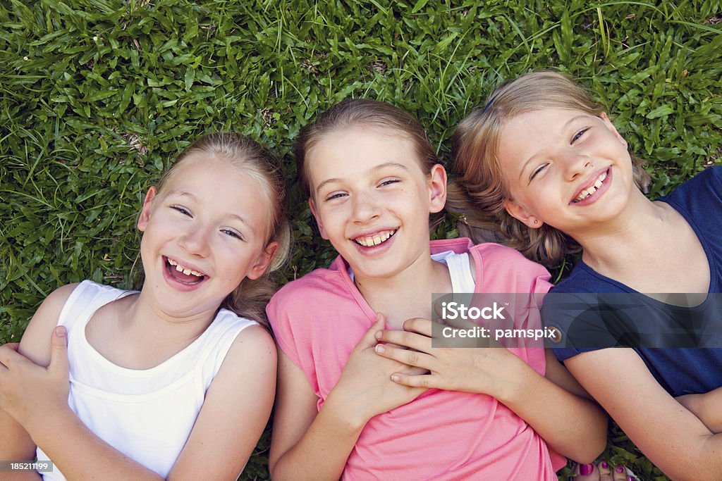 Três feliz sorridente laughting raparigas crianças situada a Relva - Royalty-free Austrália Foto de stock