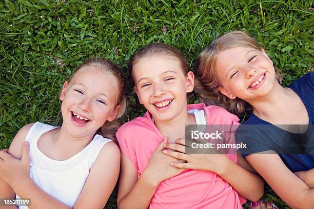 Três Feliz Sorridente Laughting Raparigas Crianças Situada A Relva - Fotografias de stock e mais imagens de Austrália