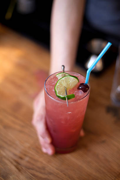 istock Pink cocktail with lime garnish and blue straw 185211413