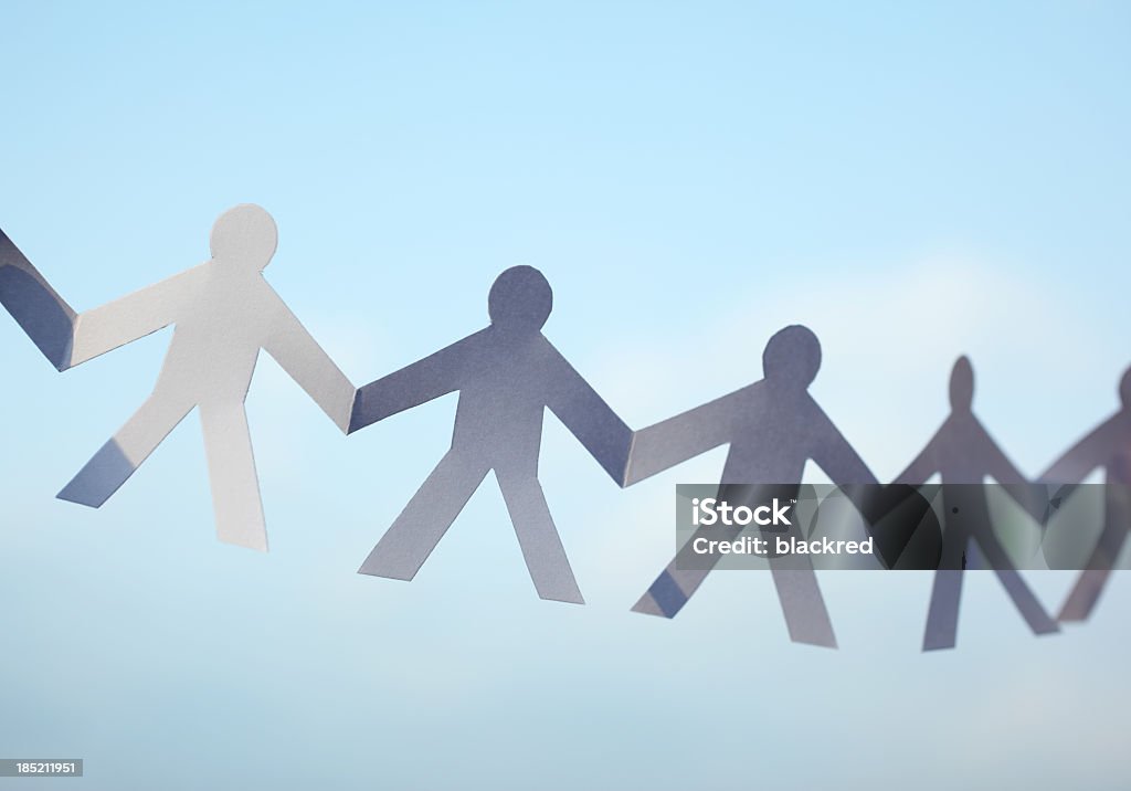 Paper Chain Men Close-up of paper chain men against nice blue sky. Paper Chain Stock Photo