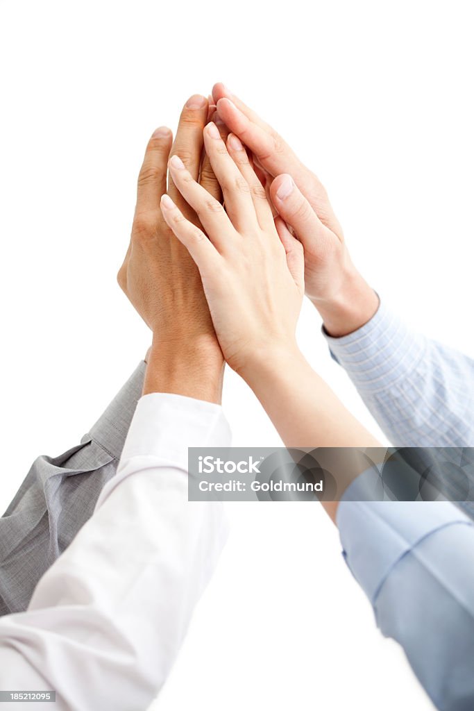 Business Team: Success! Four hands raised together to celebrate business success. Isolated on white. Business Stock Photo