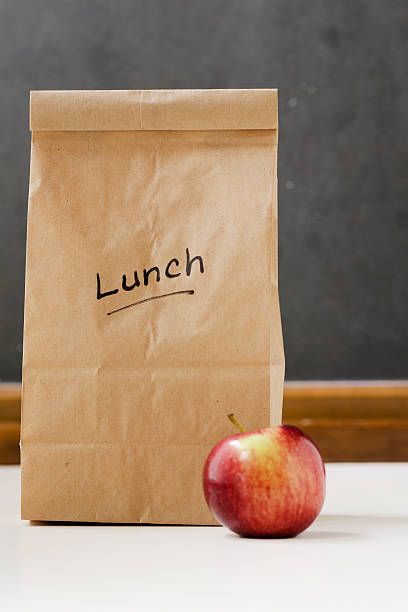 istock Lunch Bag and Apple in Front of a Chalkboard Vertical 185212518