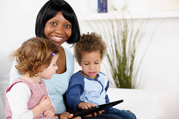 istock African American Carer Using Digital Tablet With Toddlers 185213114