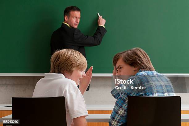 Pupils Whispering During Lesson Stock Photo - Download Image Now - 40-49 Years, 50-59 Years, Adult