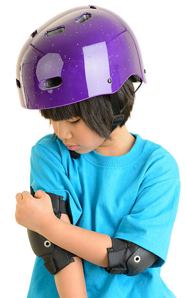 istock Young Girl Putting on Elbow Pads 185213324