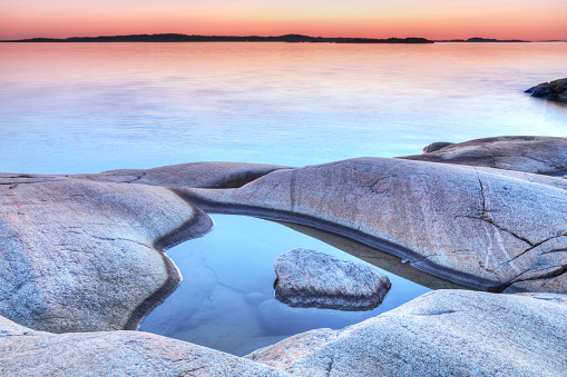 rocks in the water of the Mediterranean Sea, the water is blue and the sky is clear