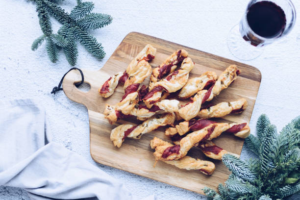 палочки для слоеного теста. крупный план слоеного теста с прошутто. - twisted cheese biscuit pastry стоковые фото и изображения