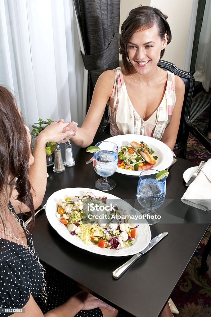 Due donna avendo una cena al ristorante-V - Foto stock royalty-free di Cena