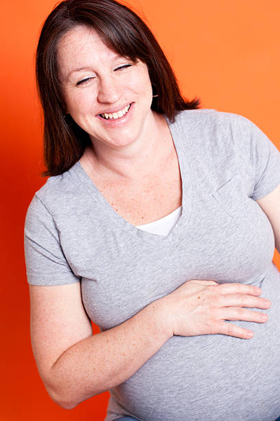 istock Pregnant Women Laughing While On Orange Background 185213555
