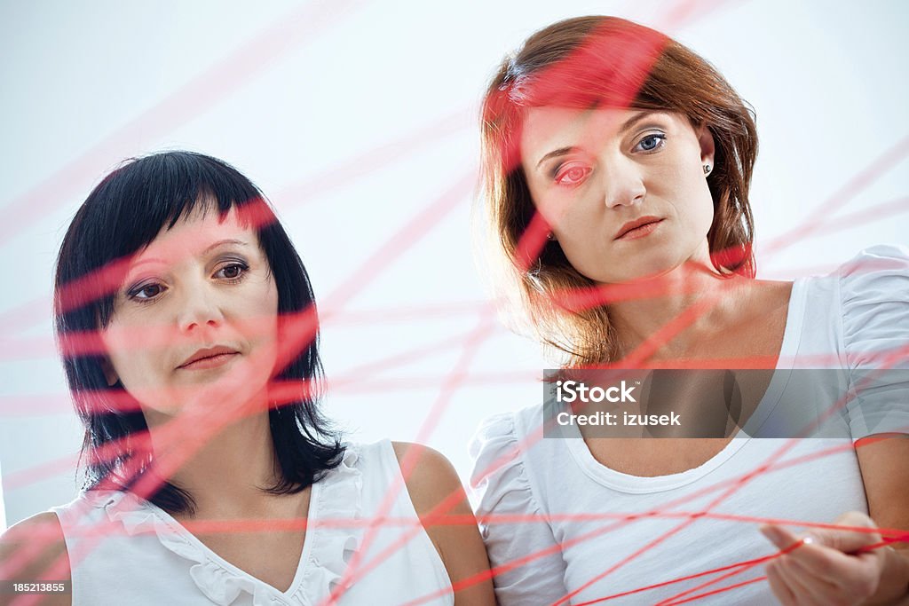 Network Network concept. Focus on two women holding red rope. Adult Stock Photo