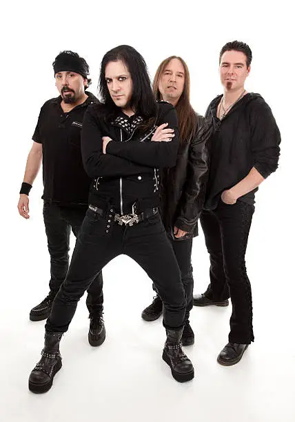 Four guys in a heavy metal band posing.