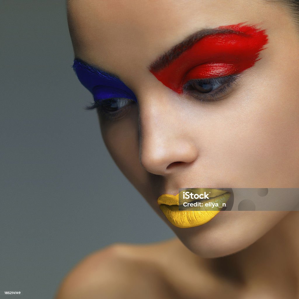 Крупный план женщина с Красный, синий и желтый макияж - Стоковые фото Взрослый роялти-фри